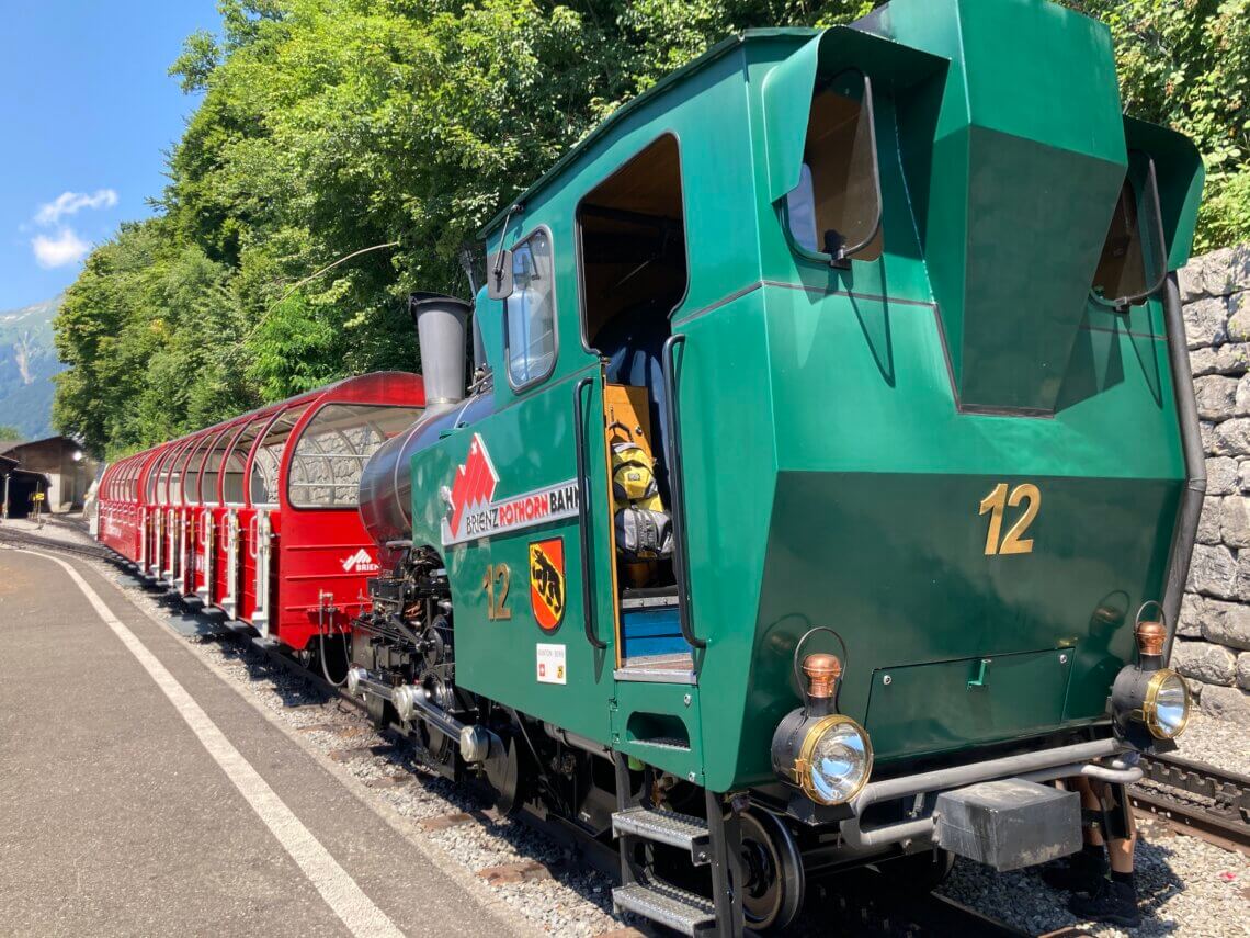 De locomotief duwt de wagons de berg op. 