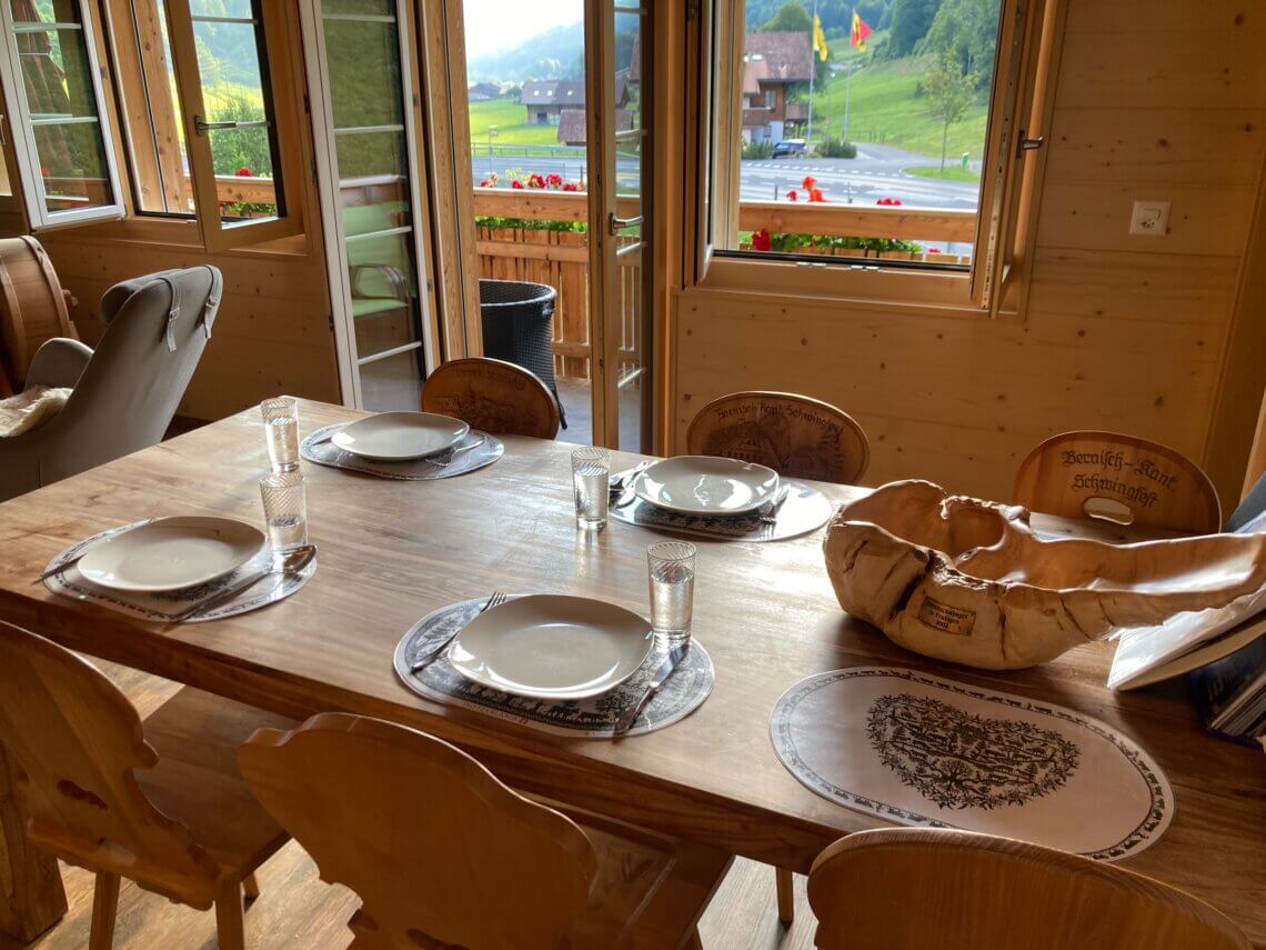 De woonkamer is ruim met een zithoek en eettafel met uitzicht op de bergen.