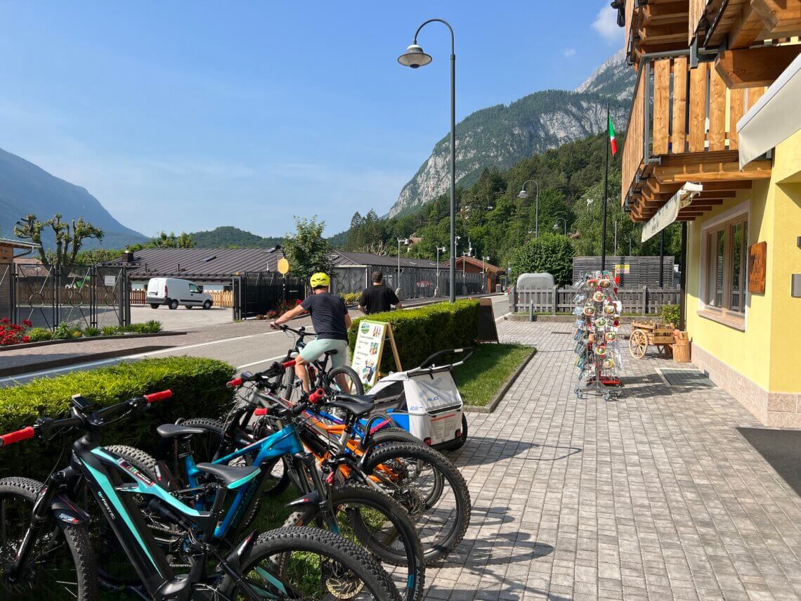 Molveno kan je mountainbikes huren tegenover camping Spiaggia Lago di Molveno bij Sportlifee Noleggio MTB.
