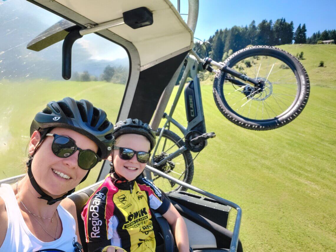 Met de fiets hangend aan de stoeltjeslift gaan wij de berg op