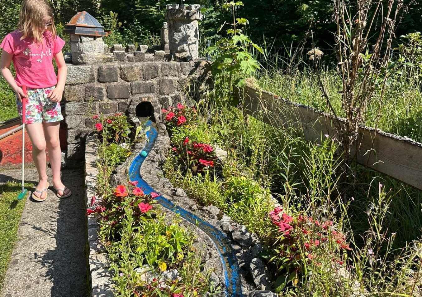 Nog zo'n mooie sprookjesachtige baan. De bal moet eerst door het kasteel en dan door het waterstroompje richting de hole. 