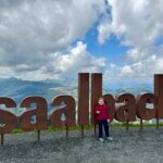 Saalbach Hinterglemm met kinderen; letters Saalbach op de berg.