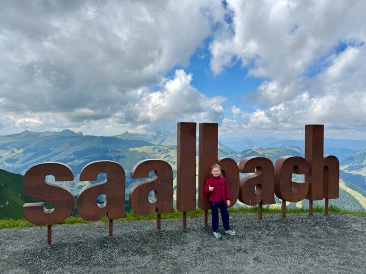 Saalbach Hinterglemm met kinderen; letters Saalbach op de berg.