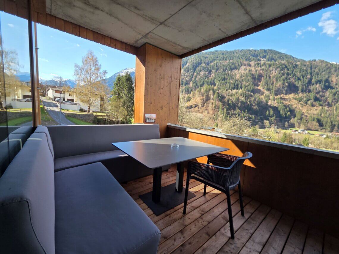 Een eettafel met comfortabele hoekbank op het balkon