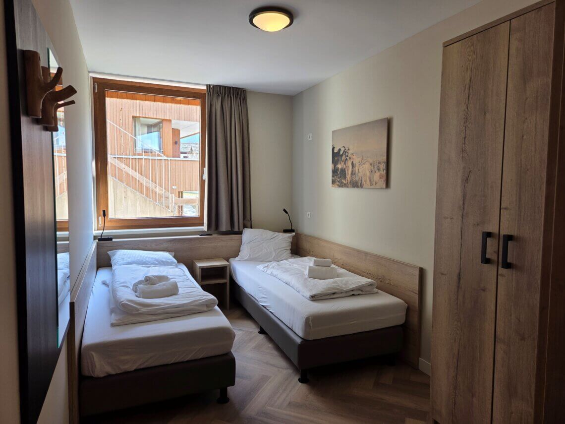 Tweede slaapkamer met 2 eenpersoons bedden en een grote hang- en legkast