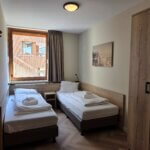 Tweede slaapkamer met 2 eenpersoons bedden en een grote hang- en legkast